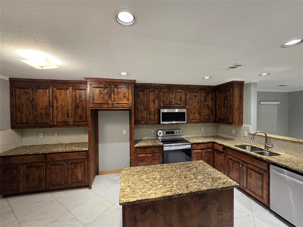 700 White Fields Way Arlington, TX 76002 - Photo 7 of 31 a kitchen with stainless steel appliances granite countertop a sink stove and refrigerator