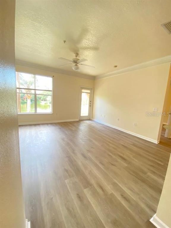 8849 Villa View Circle, Unit 203 Orlando, FL 32821 - Photo 8 of 12 an empty room with wooden floor and windows