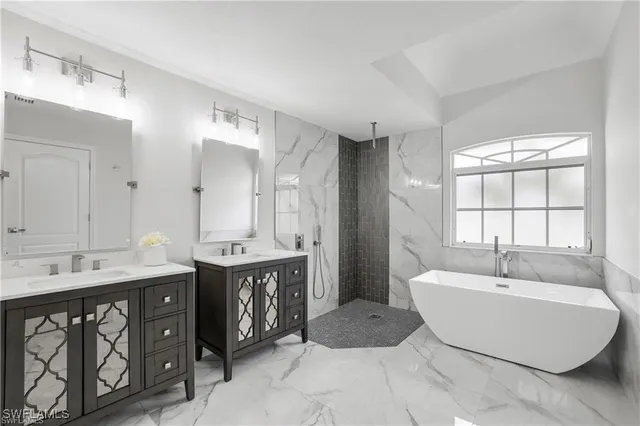 a spacious bathroom with a double vanity sink mirror and bathtub