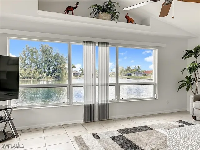 a living room with a bed furniture and next to a window