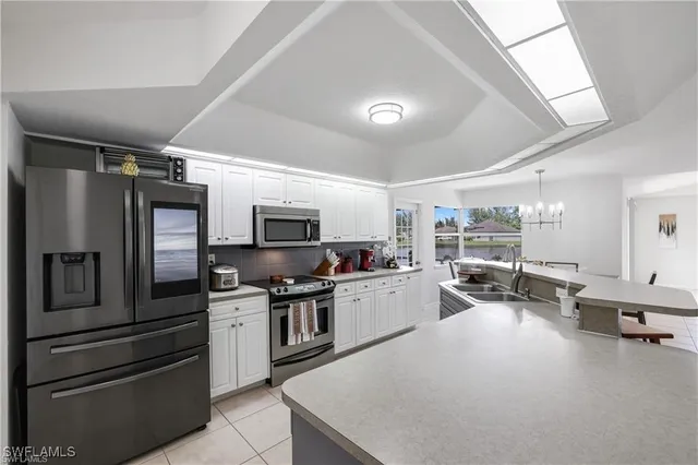 a kitchen with granite countertop a refrigerator stove and microwave