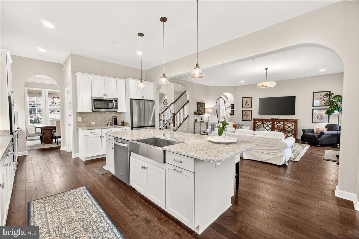 5487 Tallyn Ridge Drive Frederick, MD 21704 - Photo 15 of 80 a large kitchen with stainless steel appliances kitchen island granite countertop a lot of counter space and a wooden floor