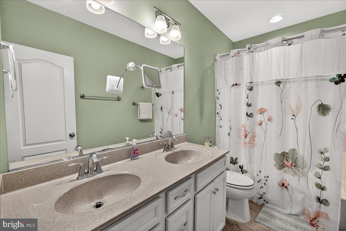 5487 Tallyn Ridge Drive Frederick, MD 21704 - Photo 43 of 80 a bathroom with a sink a toilet a mirror a vanity and shower