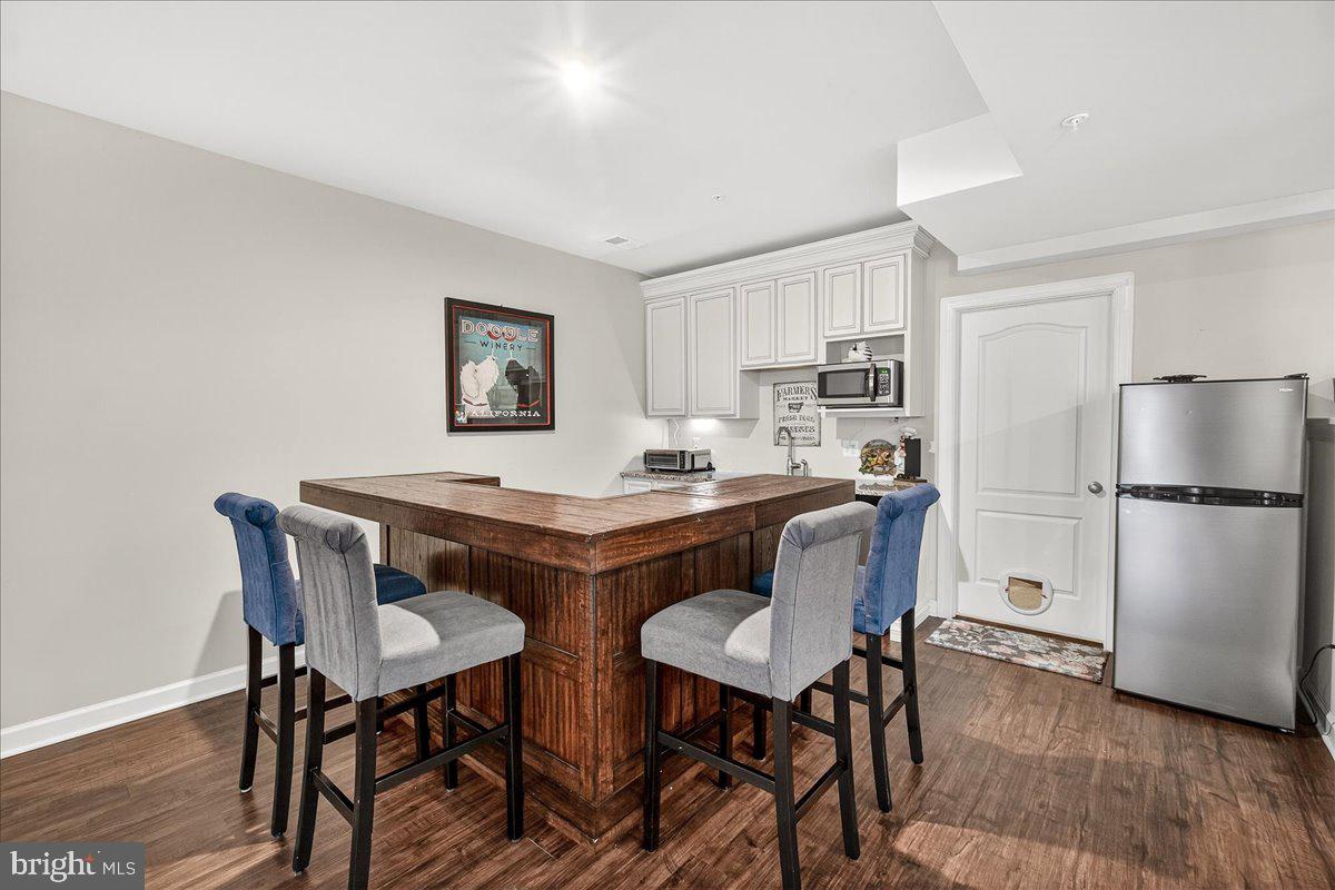 5487 Tallyn Ridge Drive Frederick, MD 21704 - Photo 53 of 80 a kitchen with a dining table chairs refrigerator and cabinets