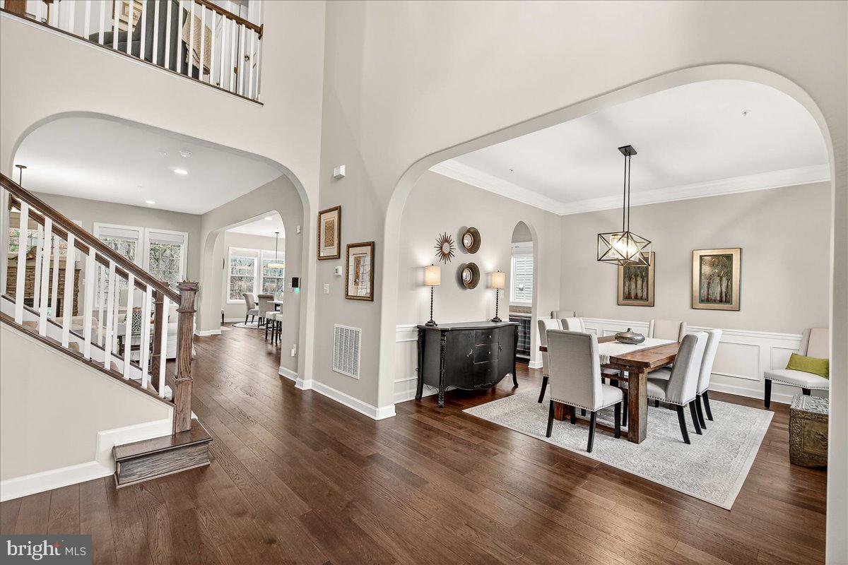 5487 Tallyn Ridge Drive Frederick, MD 21704 - Photo 6 of 80 a dining room with wooden floor a chandelier a wooden table and chairs