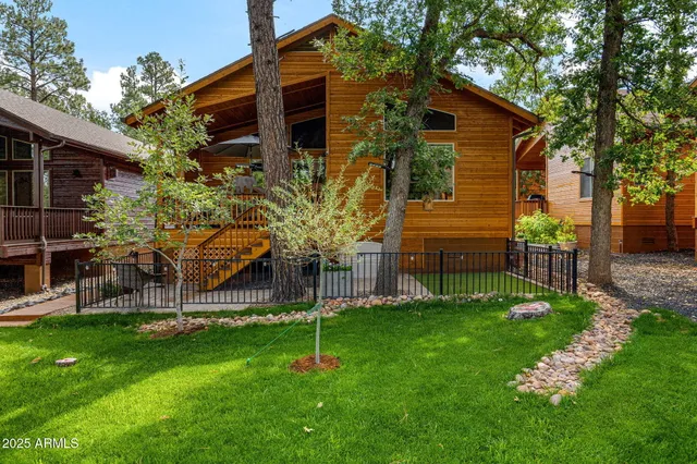 a view of a house with a wooden deck and a large tree