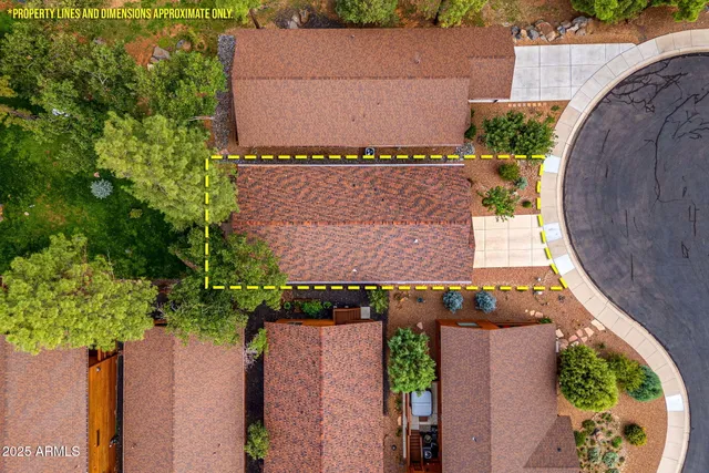 an aerial view of a house with a yard and large trees