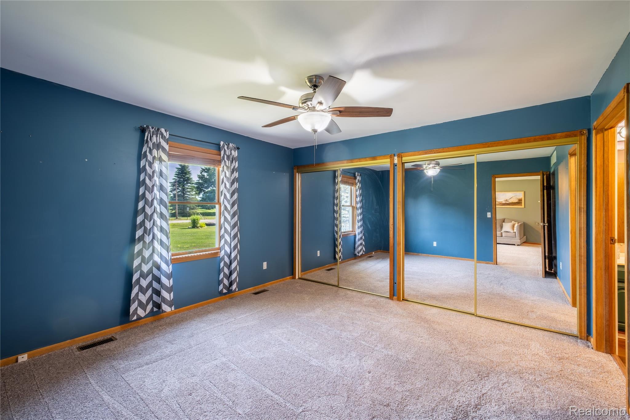 9600 Hamill Road Otisville, MI 48463 - Photo 13 of 32 Spacious room featuring a ceiling fan, light-toned carpet, and a large window with wood trim