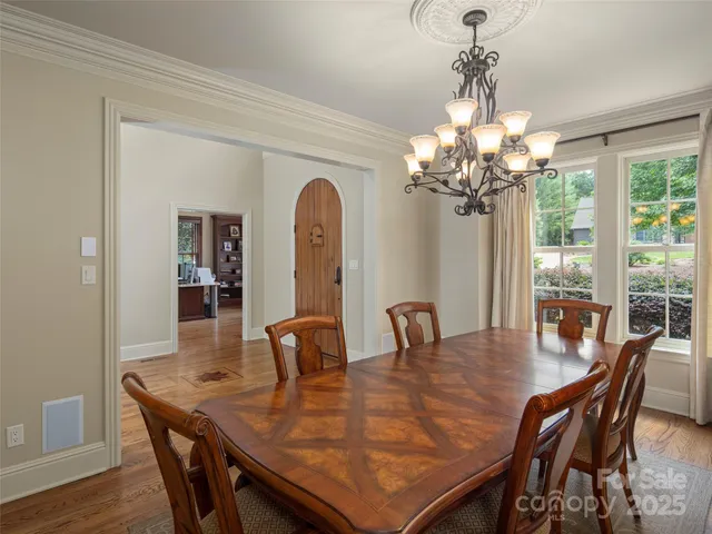 a dining room with furniture a chandelier and wooden floor