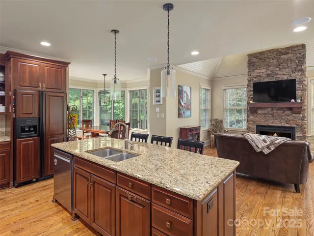 a kitchen with granite countertop kitchen island stainless steel appliances a sink stove and refrigerator