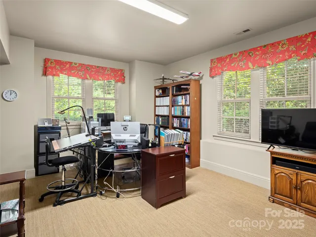 a view of a workspace with furniture and a window