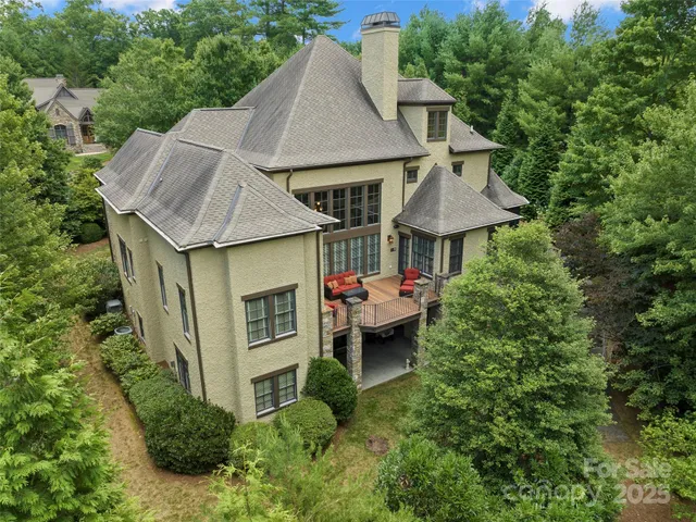 a aerial view of a house with table and chairs under an umbrella