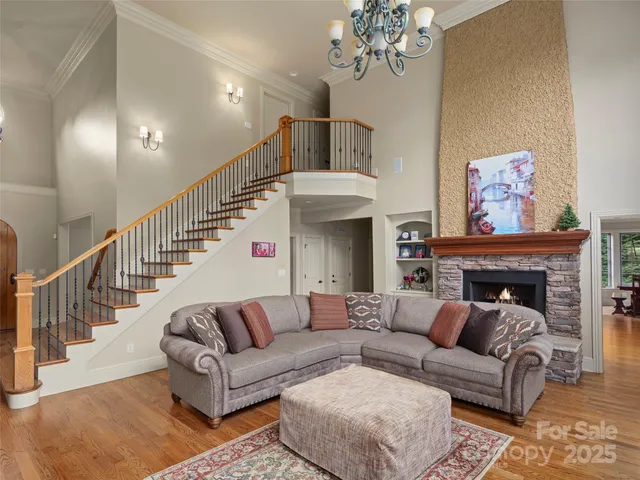 a living room with furniture a chandelier and a fireplace