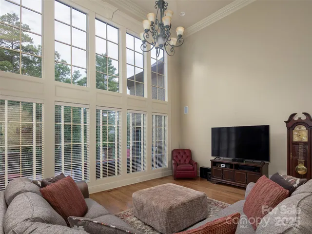 a living room with furniture a flat screen tv and a large window