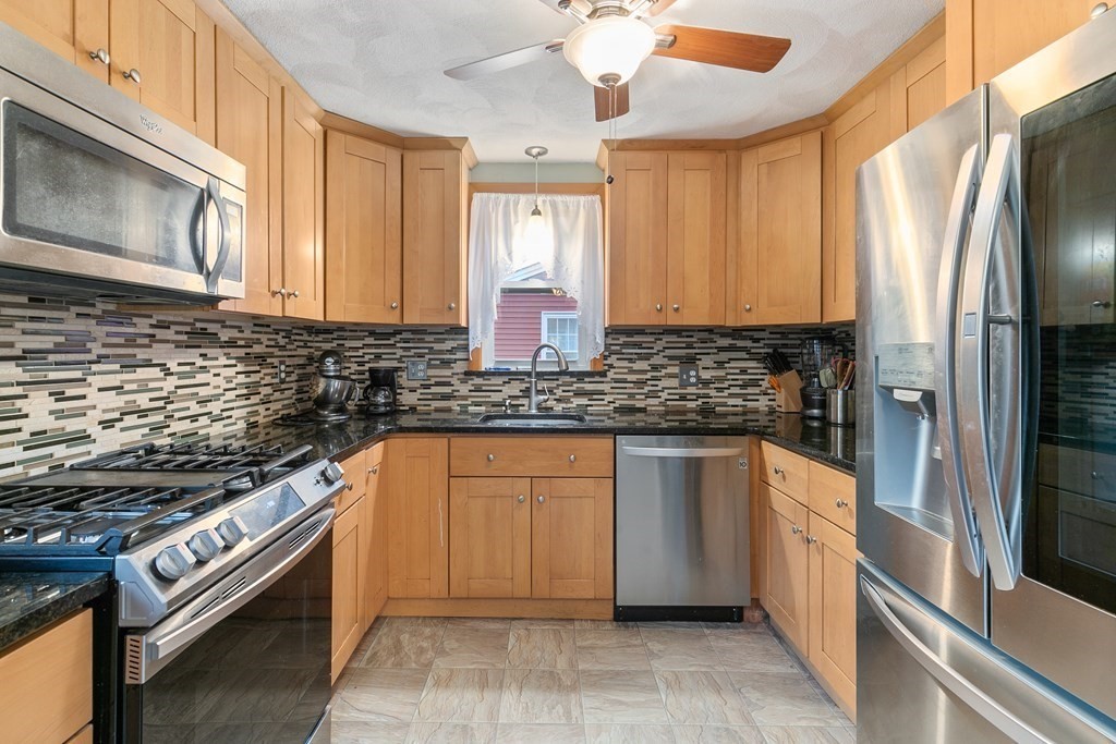 44 Wright Street Stoneham, MA 02180 - Photo 13 of 38 a kitchen with stainless steel appliances granite countertop a stove a sink and a microwave