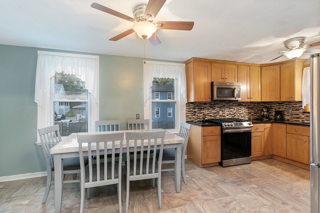 44 Wright Street Stoneham, MA 02180 - Photo 29 of 38 a kitchen with a stove a sink a dining table and chairs