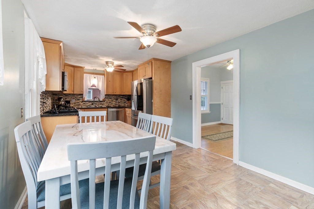 44 Wright Street Stoneham, MA 02180 - Photo 7 of 38 a kitchen with stainless steel appliances kitchen island granite countertop a refrigerator a stove a sink dishwasher a dining table and chairs with wooden floor