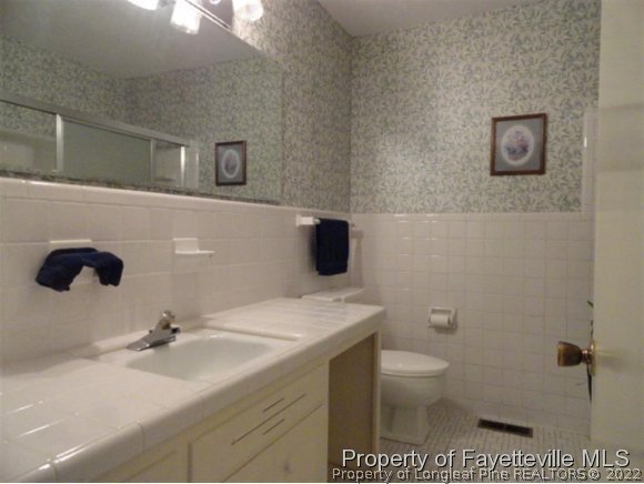 4667 Legion Road Hope Mills, NC 28348 - Photo 17 of 24 a bathroom with a sink a toilet and a mirror