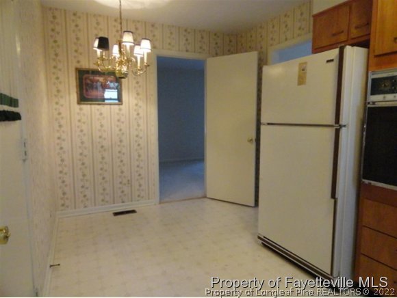 4667 Legion Road Hope Mills, NC 28348 - Photo 4 of 24 a view of a kitchen with a refrigerator a microwave and a sink