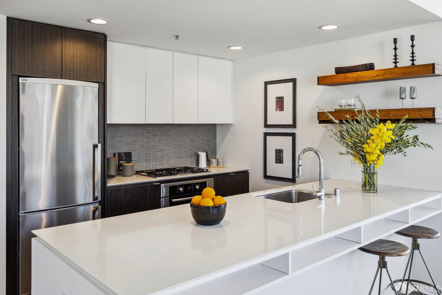 1788 Clay Street, Unit 807 San Francisco, CA 94109 - Photo 12 of 28 a kitchen with stainless steel appliances granite countertop a refrigerator a stove and a sink with wooden floor