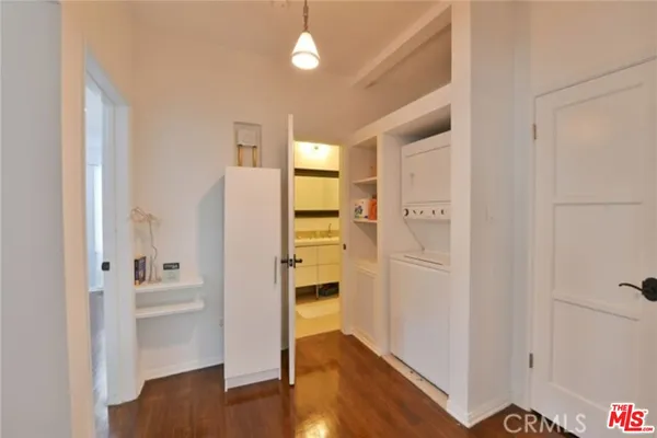 a view of a hallway with wooden floor and cabinet