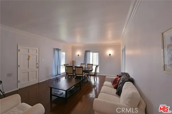 a living room with furniture a rug and a dining table