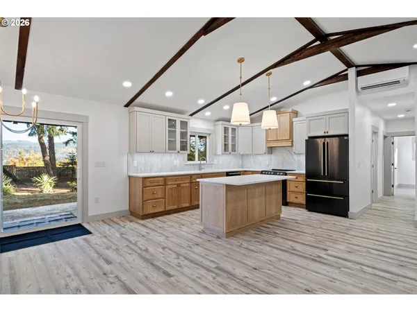 a large kitchen with kitchen island wooden floors appliances and cabinets