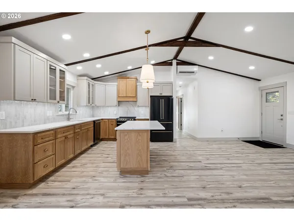 a kitchen with stainless steel appliances granite countertop a sink refrigerator and cabinets