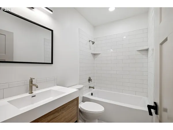 a bathroom with a sink double vanity granite tub shower and a mirror