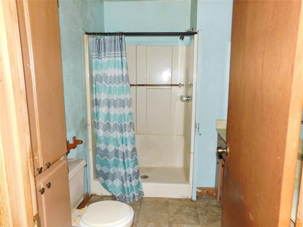 104 North Pecan Avenue Hubbard, TX 76648 - Photo 14 of 21 a bathroom with a granite countertop shower and a toilet