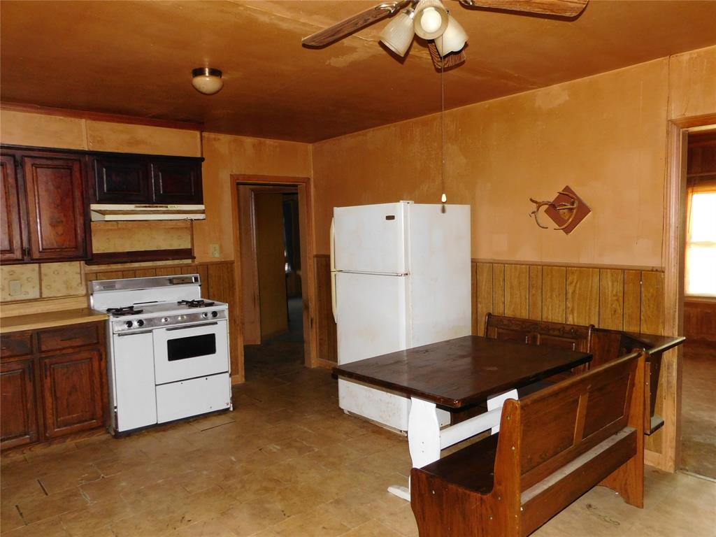 104 North Pecan Avenue Hubbard, TX 76648 - Photo 6 of 21 a kitchen with a stove and a refrigerator