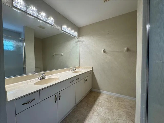 a spacious bathroom with a double vanity sink and a mirror