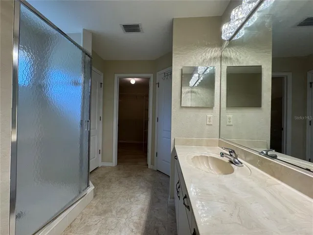 a spacious bathroom with a granite countertop tub sink and mirror