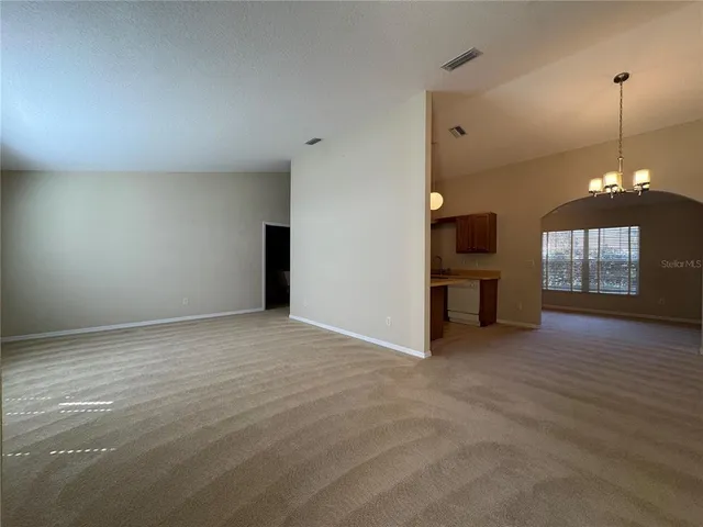 a view of empty room with wooden floor and ceiling fan