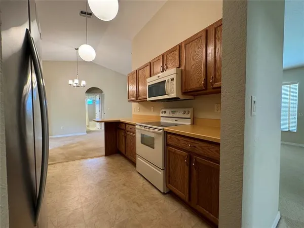 a kitchen with stainless steel appliances granite countertop a refrigerator a stove a sink and a microwave
