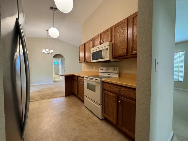 a kitchen with stainless steel appliances granite countertop a refrigerator a stove a sink and a microwave