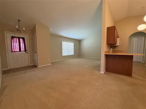 a view of an empty room with window and bathroom