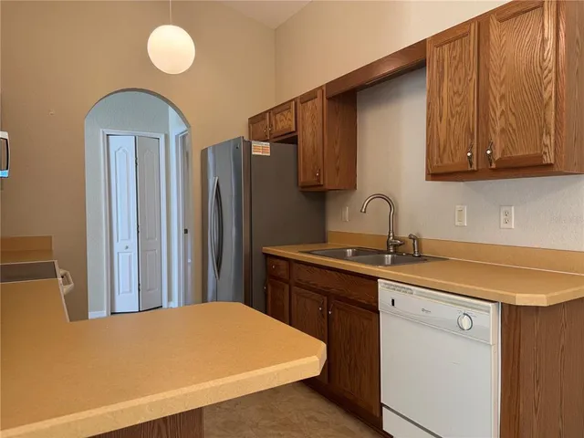 a kitchen with stainless steel appliances a sink cabinets and wooden floor
