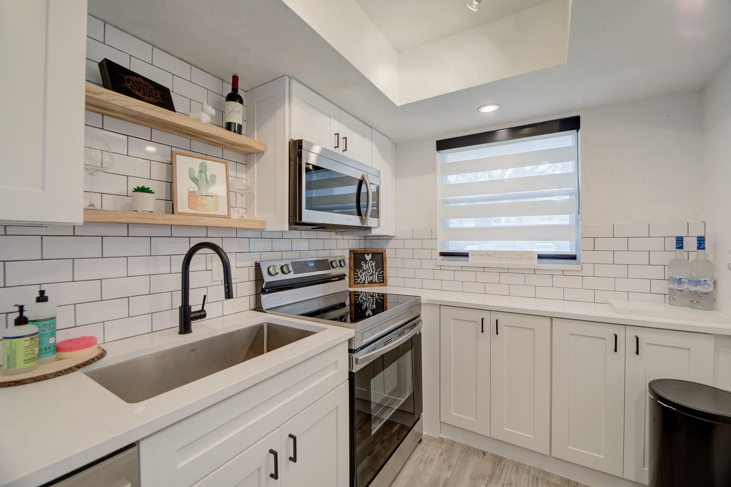 a kitchen with white cabinets a sink and appliances