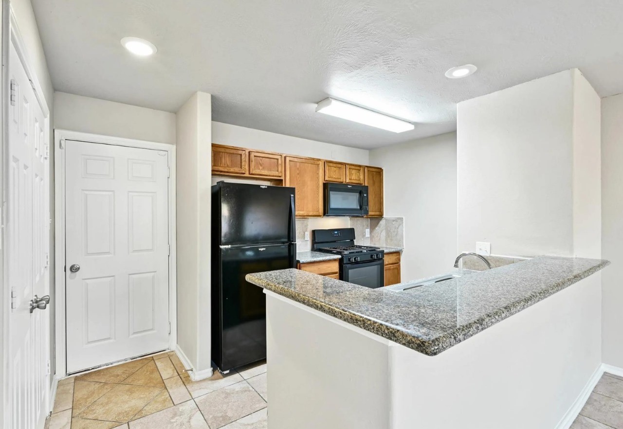 12010 Sarah Lake Drive Houston, TX 77099 - Photo 11 of 20 a kitchen with stainless steel appliances granite countertop a sink and a refrigerator