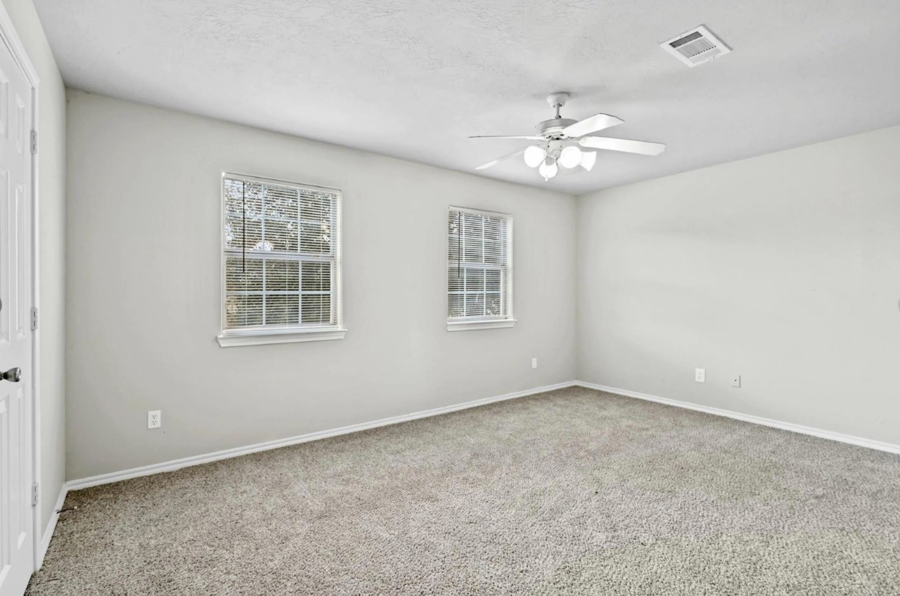 12010 Sarah Lake Drive Houston, TX 77099 - Photo 17 of 20 an empty room with windows and ceiling fan