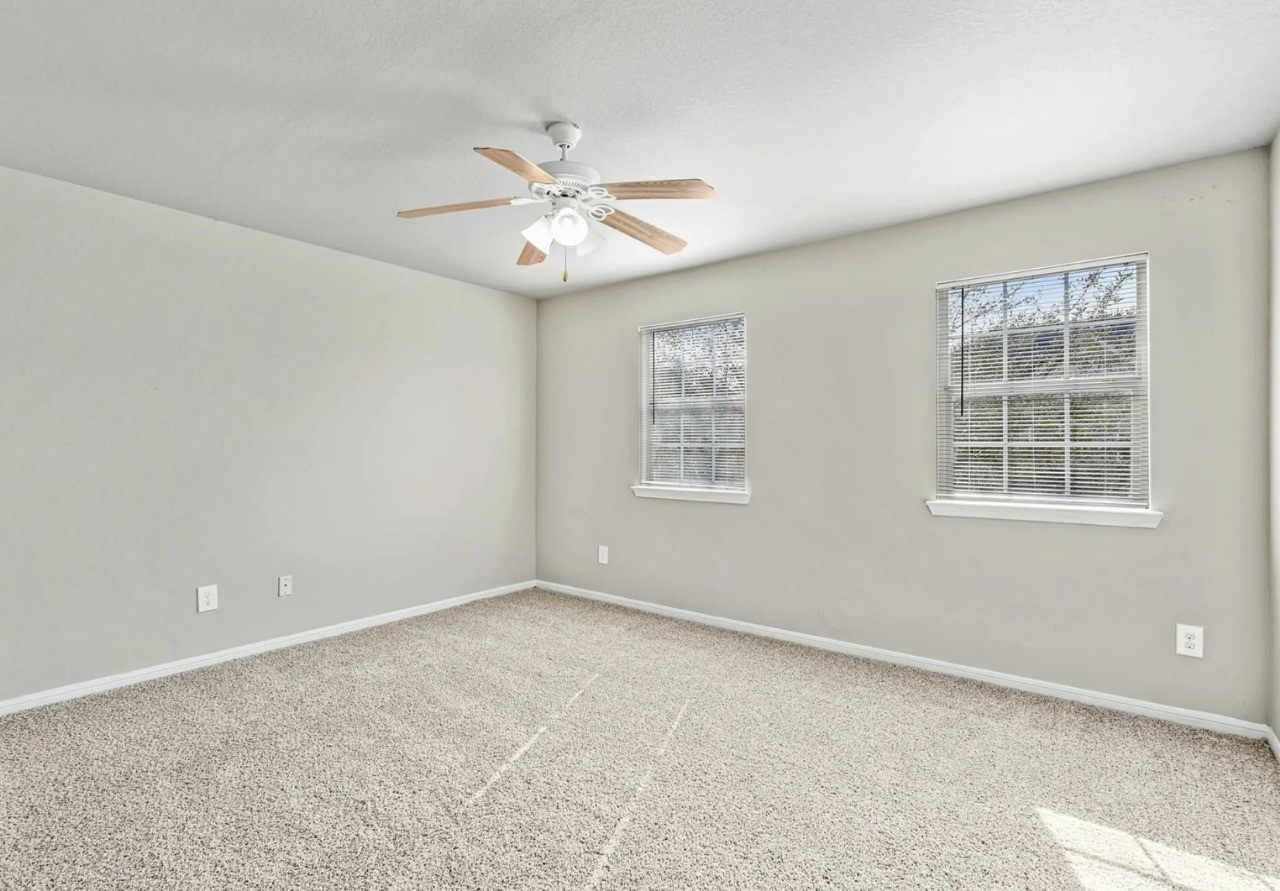 12010 Sarah Lake Drive Houston, TX 77099 - Photo 9 of 20 an empty room with windows and fan