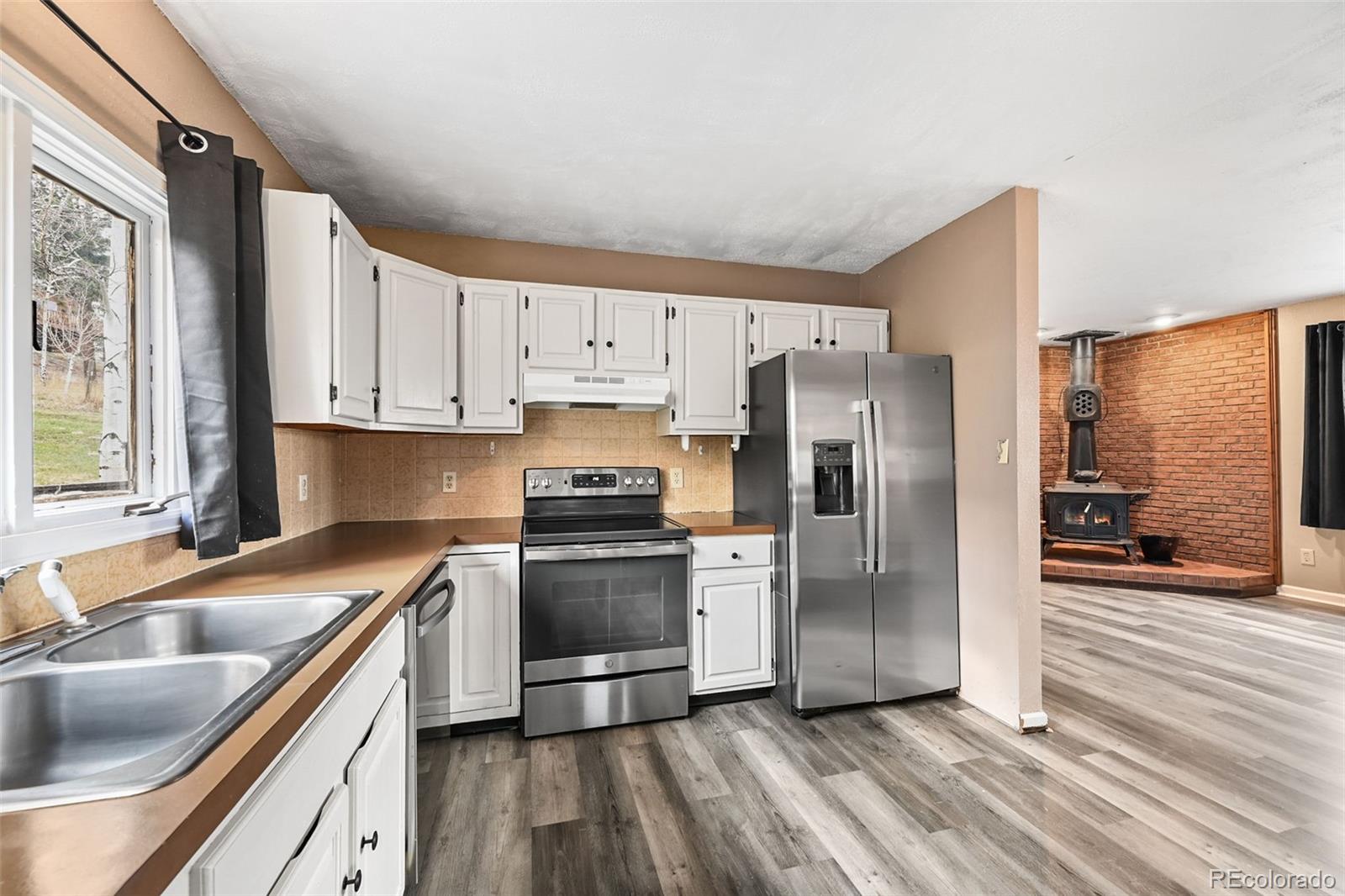 312 South Pine Drive Bailey, CO 80421 - Photo 11 of 32 a kitchen with granite countertop a refrigerator and a sink