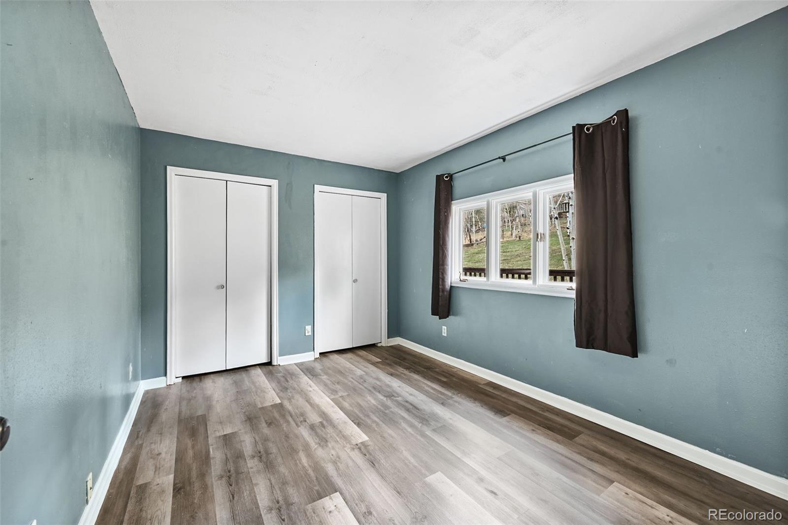 312 South Pine Drive Bailey, CO 80421 - Photo 18 of 32 a view of an empty room with wooden floor and a window