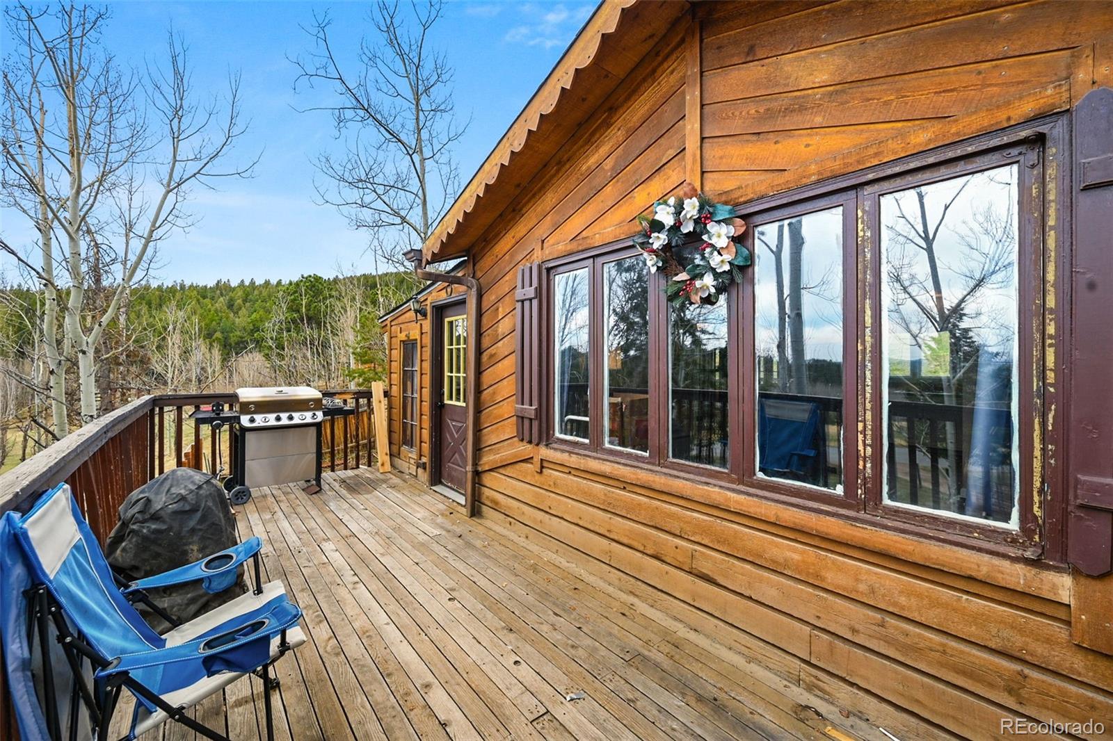 312 South Pine Drive Bailey, CO 80421 - Photo 4 of 32 a view of a balcony with chairs and wooden floor