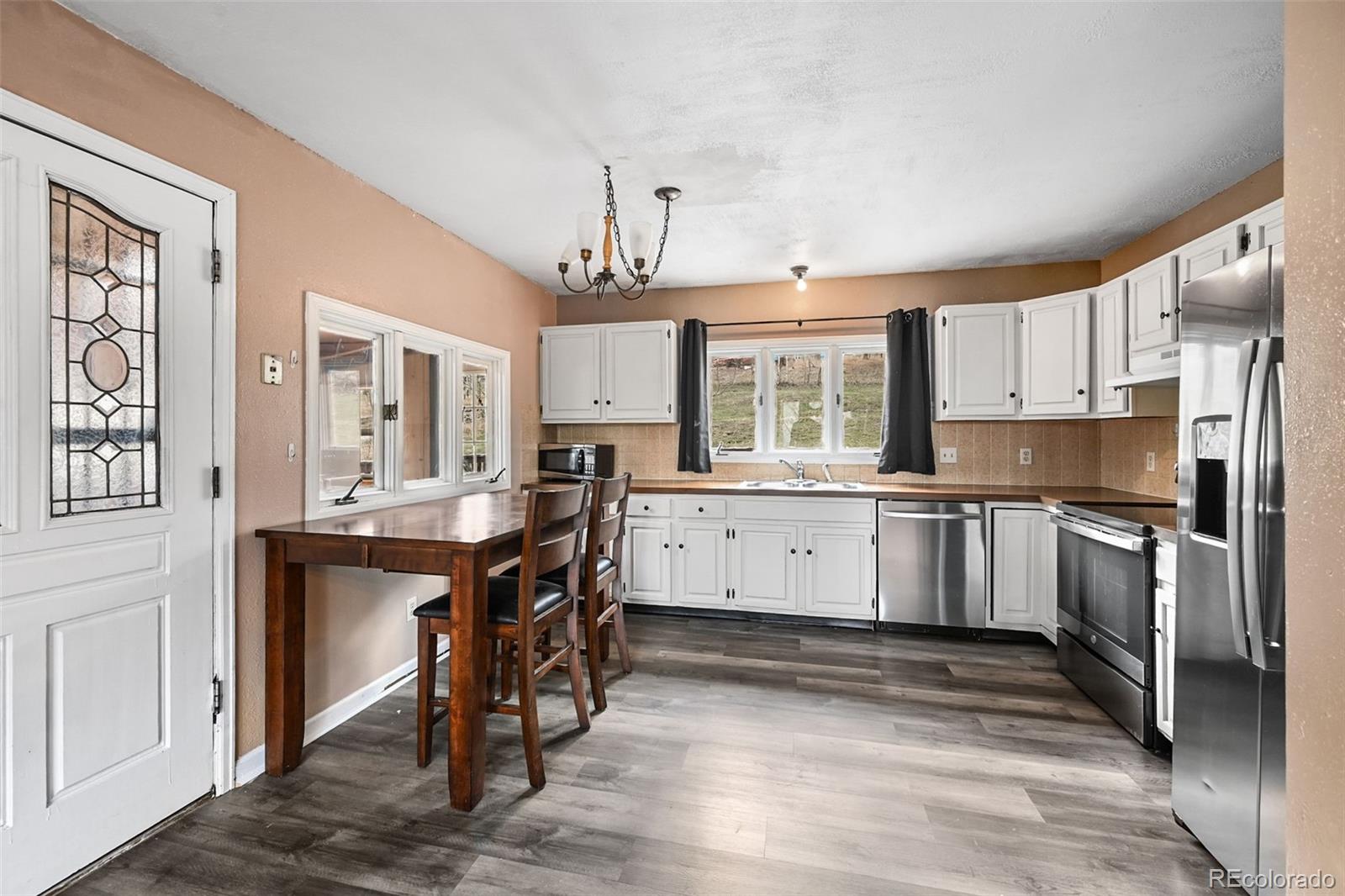 312 South Pine Drive Bailey, CO 80421 - Photo 9 of 32 a kitchen with a sink stove cabinets and wooden floor