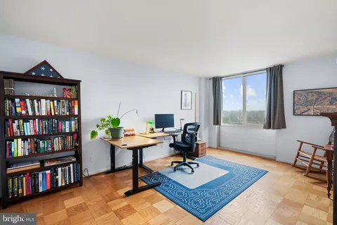 a living room with furniture and a book shelf