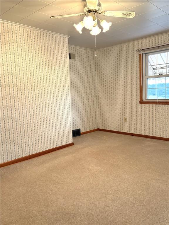 1920 Ridge Avenue New Kensington, PA 15068 - Photo 14 of 19 an empty room with a chandelier fan and windows