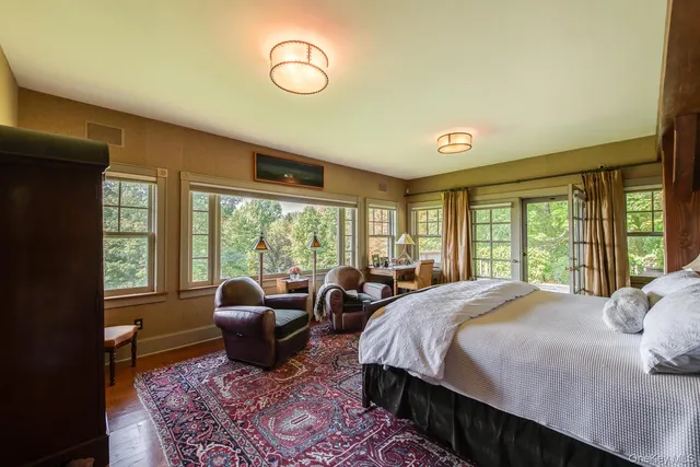 a spacious bedroom with a bed a table and chair