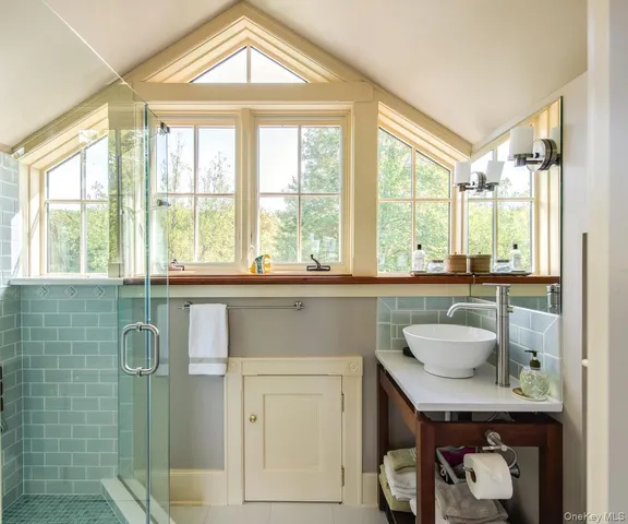 a bathroom with a granite countertop sink and a window